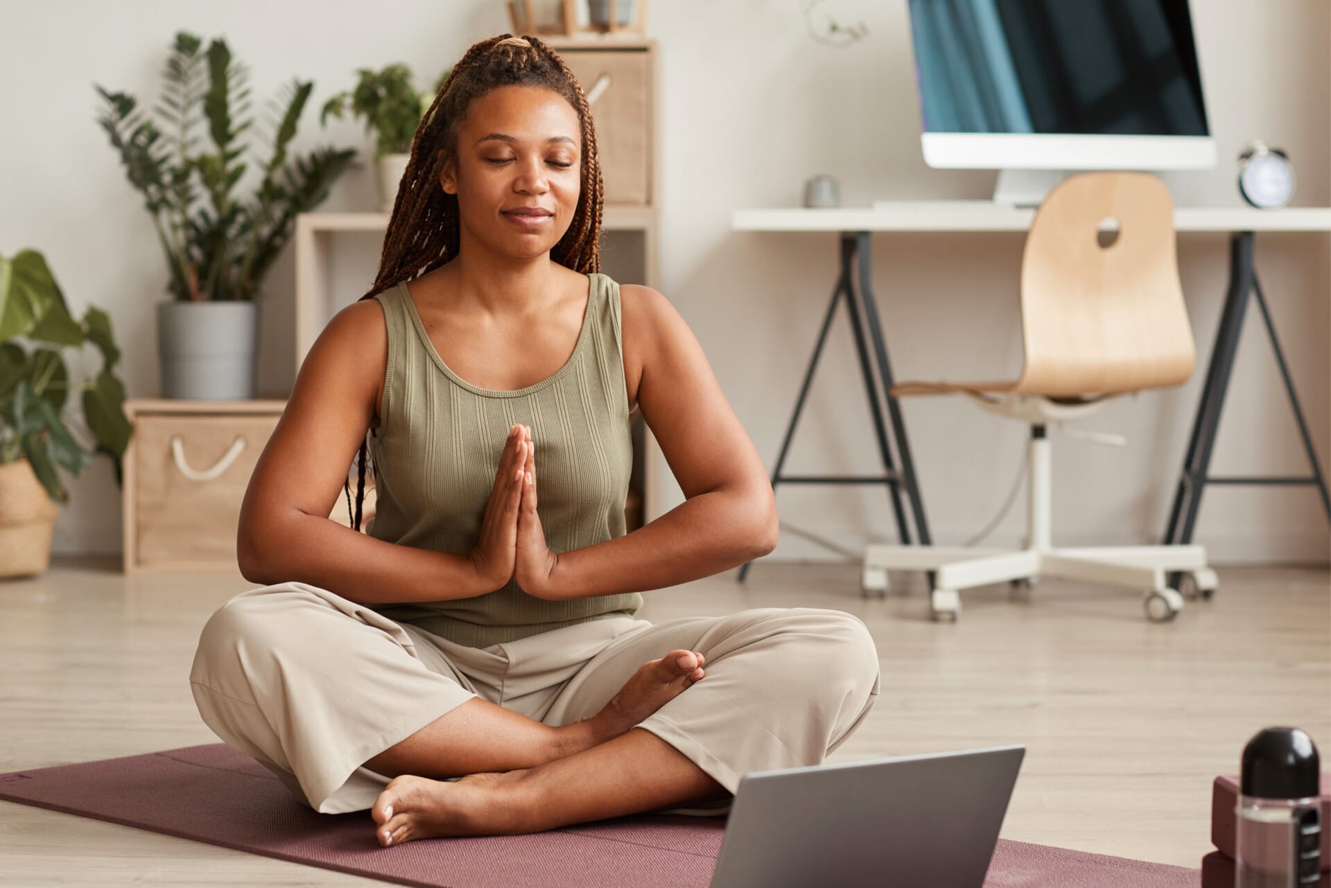 A woman meditating on a mat. Image @Canva.